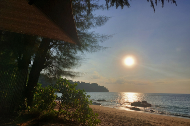 Khao Lak Sonnenuntergang am Strand von Khao Lak mit ruhigem Meer, goldener Abendsonne und tropischer Vegetation